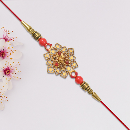 Traditional Golden Floral Rakhi With Intricate Design And Red Beads On Red Thread