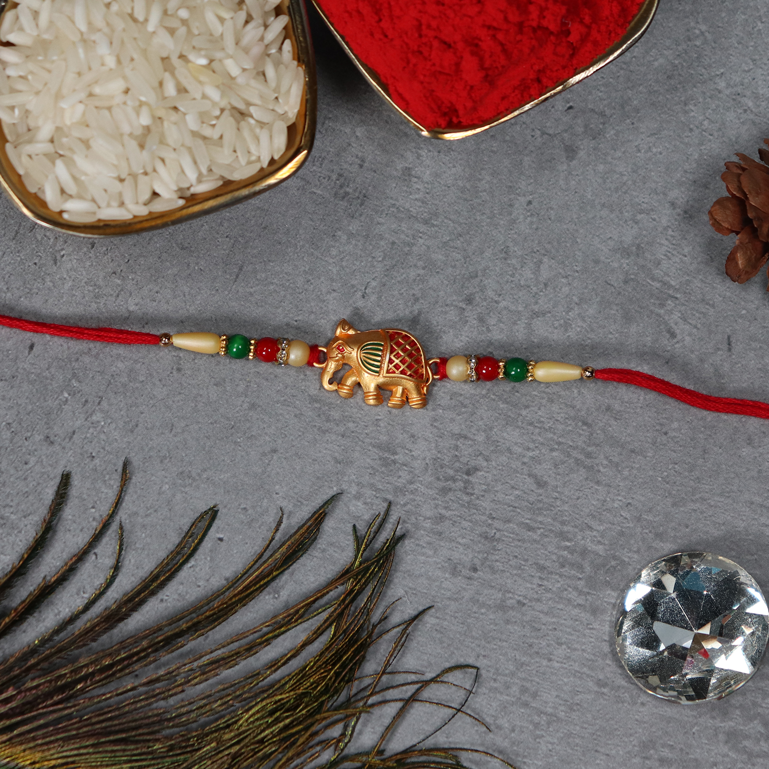 Golden Elephant Rakhi With Red Green Moti